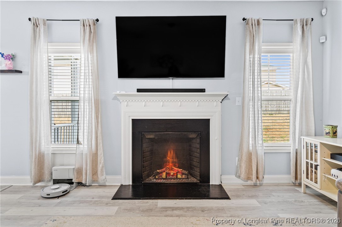 121 Colonist Place Cameron, NC 28326 - Photo 20 of 46 a living room with a fireplace a flat screen tv and a window