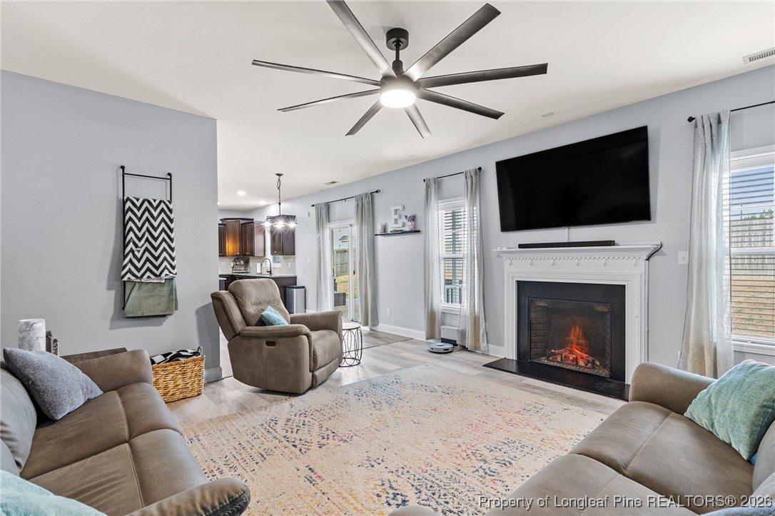 121 Colonist Place Cameron, NC 28326 - Photo 22 of 46 a living room with furniture a flat screen tv and a fireplace