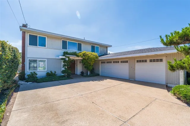 a front view of house with yard and trees around