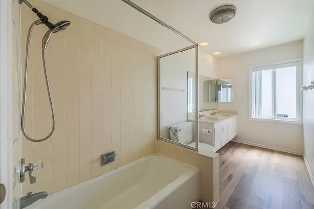 a bathroom with a tub sink and mirror