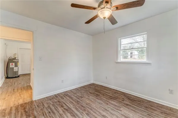 an empty room with wooden floor chandelier fan and closet