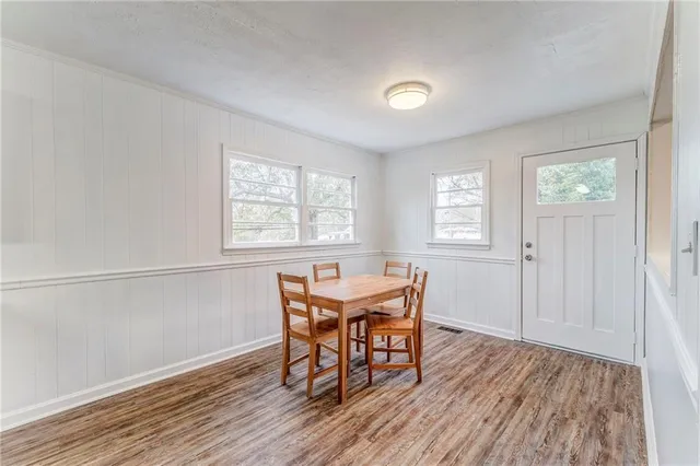 a view of a kitchen with kitchen island wooden floor and stainless steel appliances
