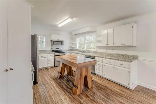 a kitchen with granite countertop a sink stove and refrigerator