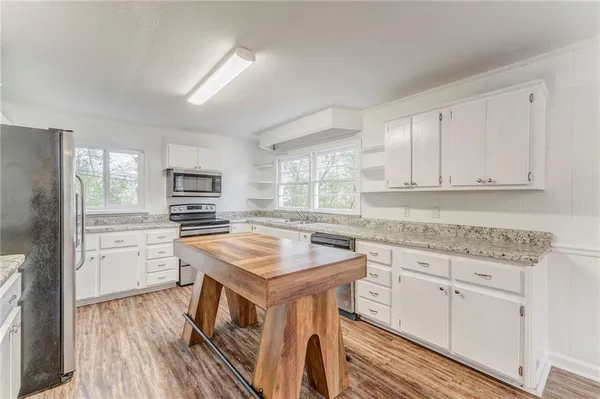 a sink with granite countertop cabinets and a wooden floor