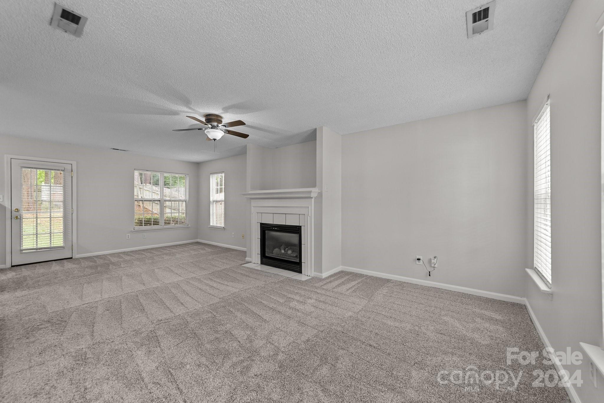 8424 Conner Ridge Lane Charlotte, NC 28269 - Photo 11 of 48 a view of an empty room with a fireplace and a window