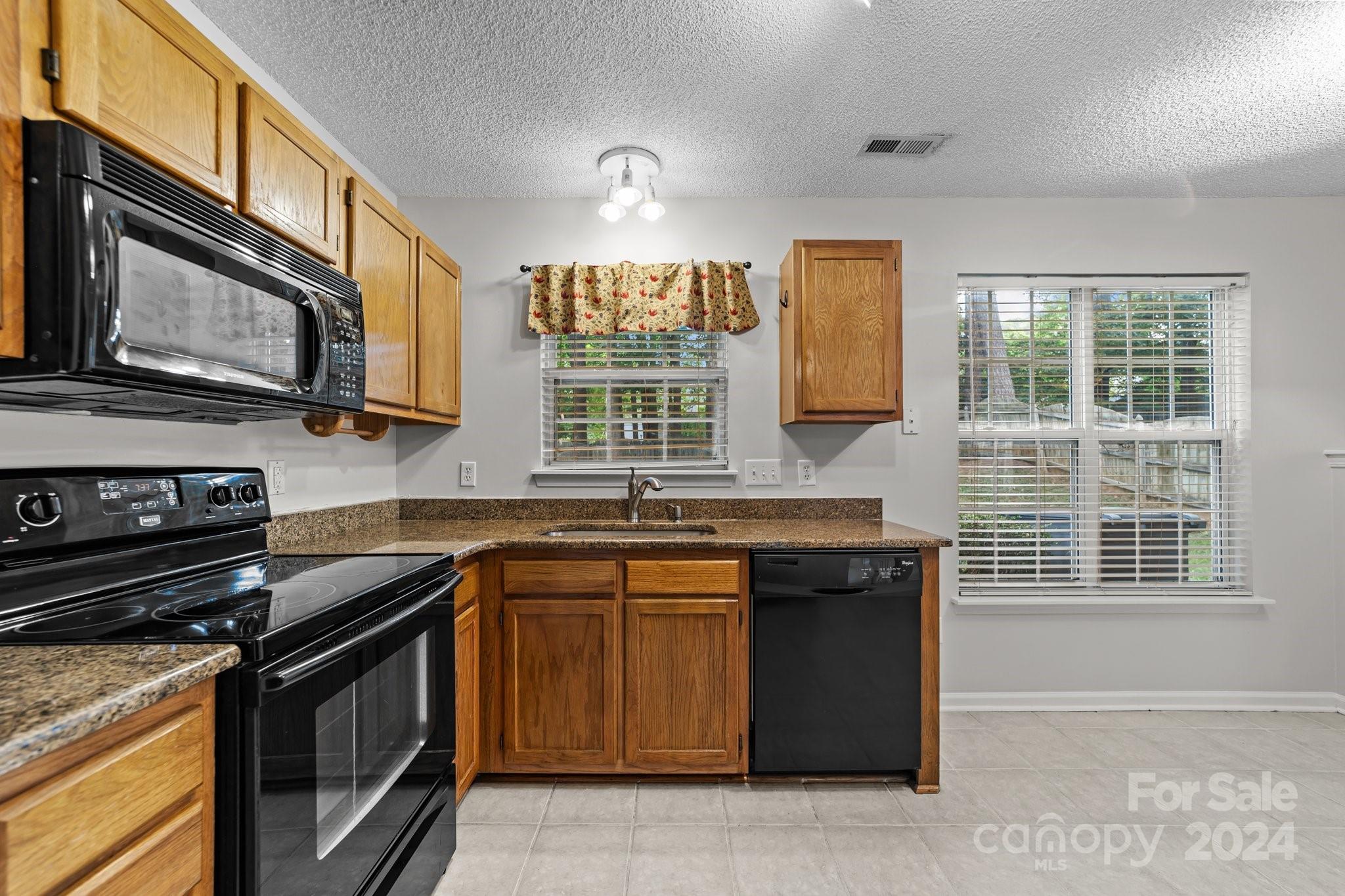 8424 Conner Ridge Lane Charlotte, NC 28269 - Photo 16 of 48 a kitchen with stainless steel appliances granite countertop a stove microwave and cabinets