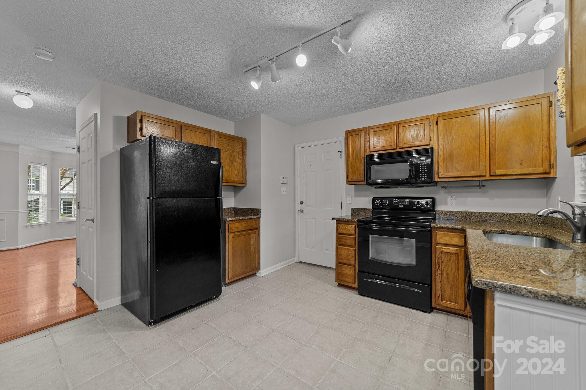 8424 Conner Ridge Lane Charlotte, NC 28269 - Photo 20 of 48 a kitchen with granite countertop a refrigerator and a stove top oven