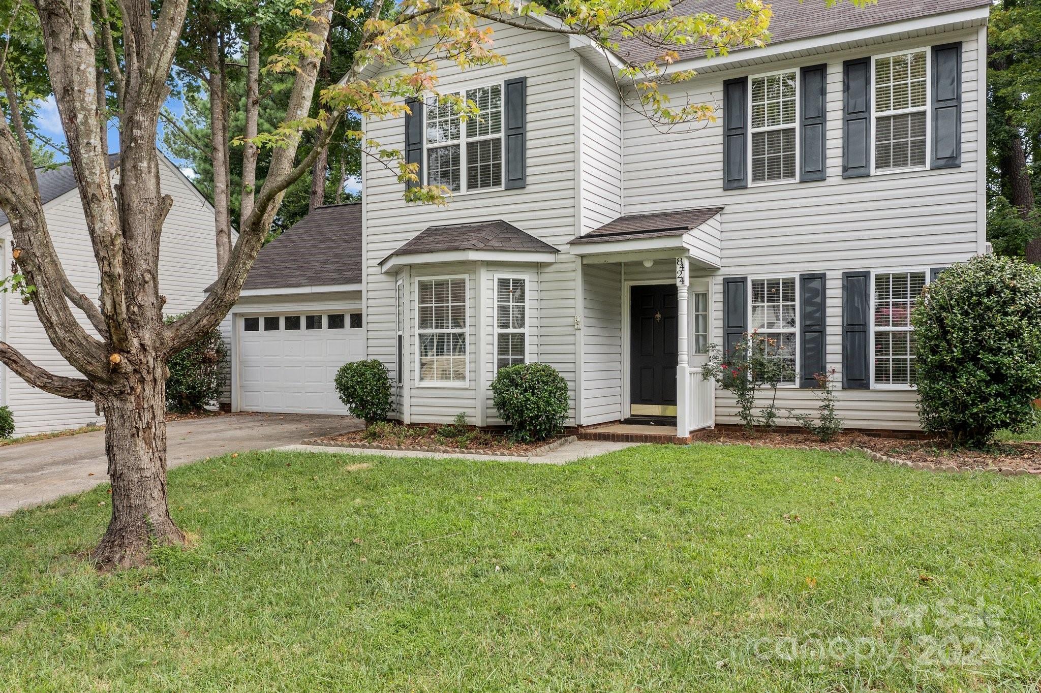 8424 Conner Ridge Lane Charlotte, NC 28269 - Photo 2 of 48 a front view of a house with a yard and garage