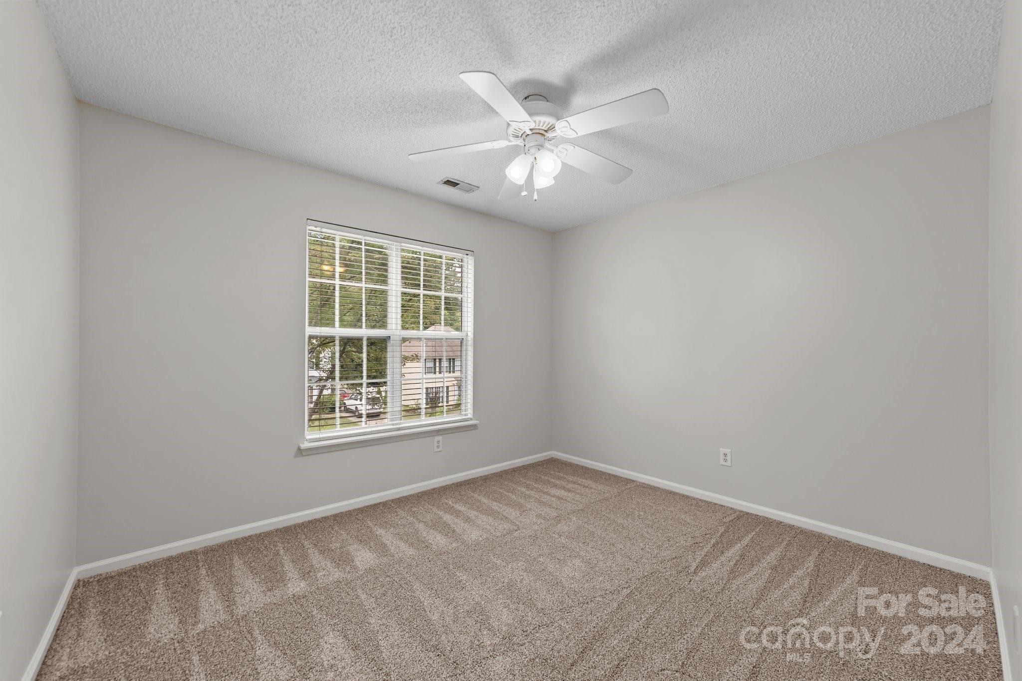 8424 Conner Ridge Lane Charlotte, NC 28269 - Photo 32 of 48 an empty room with a window and a fan