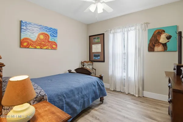 a bedroom with a bed and a painting on the wall