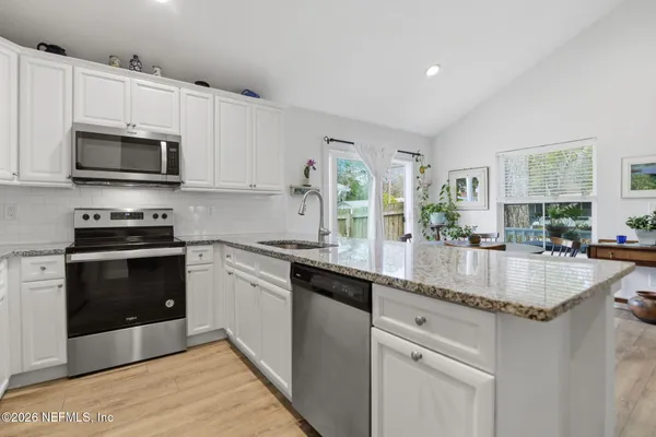 a kitchen with stainless steel appliances granite countertop a sink stove and microwave