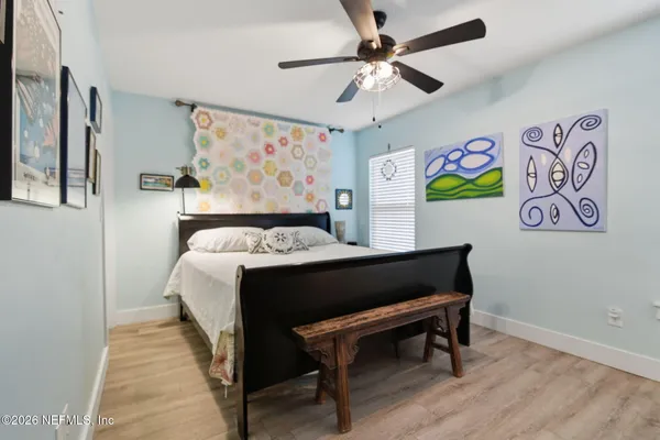 a bedroom with a bed and paintings on the wall