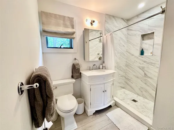 a bathroom with a toilet sink and shower