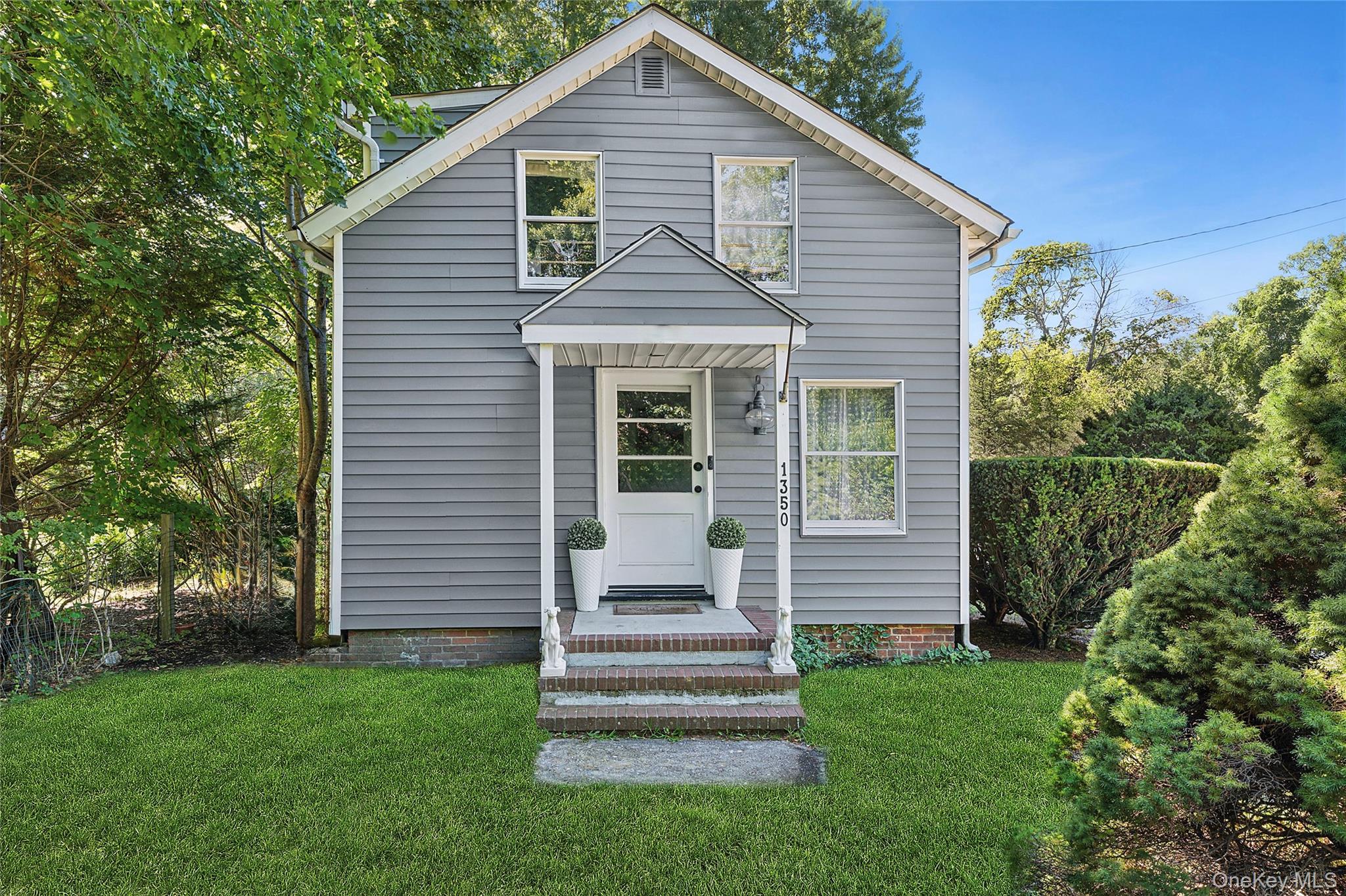 1350 Brick Kiln Road Sag Harbor, NY 11963 - Photo 2 of 21 a front view of a house with a garden