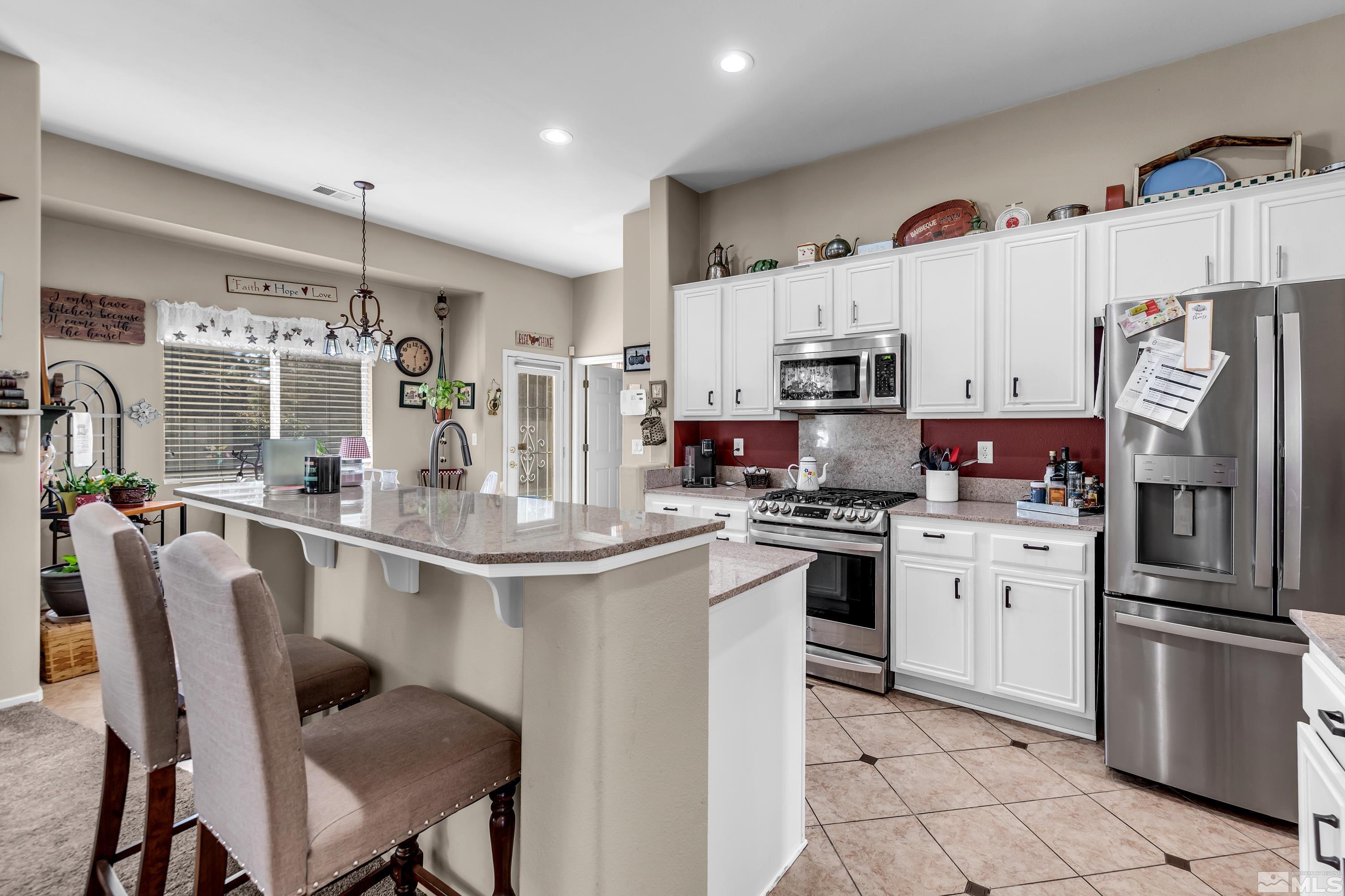1496 Gaucho Lane Reno, NV 89521 - Photo 15 of 40 a kitchen with stainless steel appliances granite countertop a stove refrigerator sink and cabinets