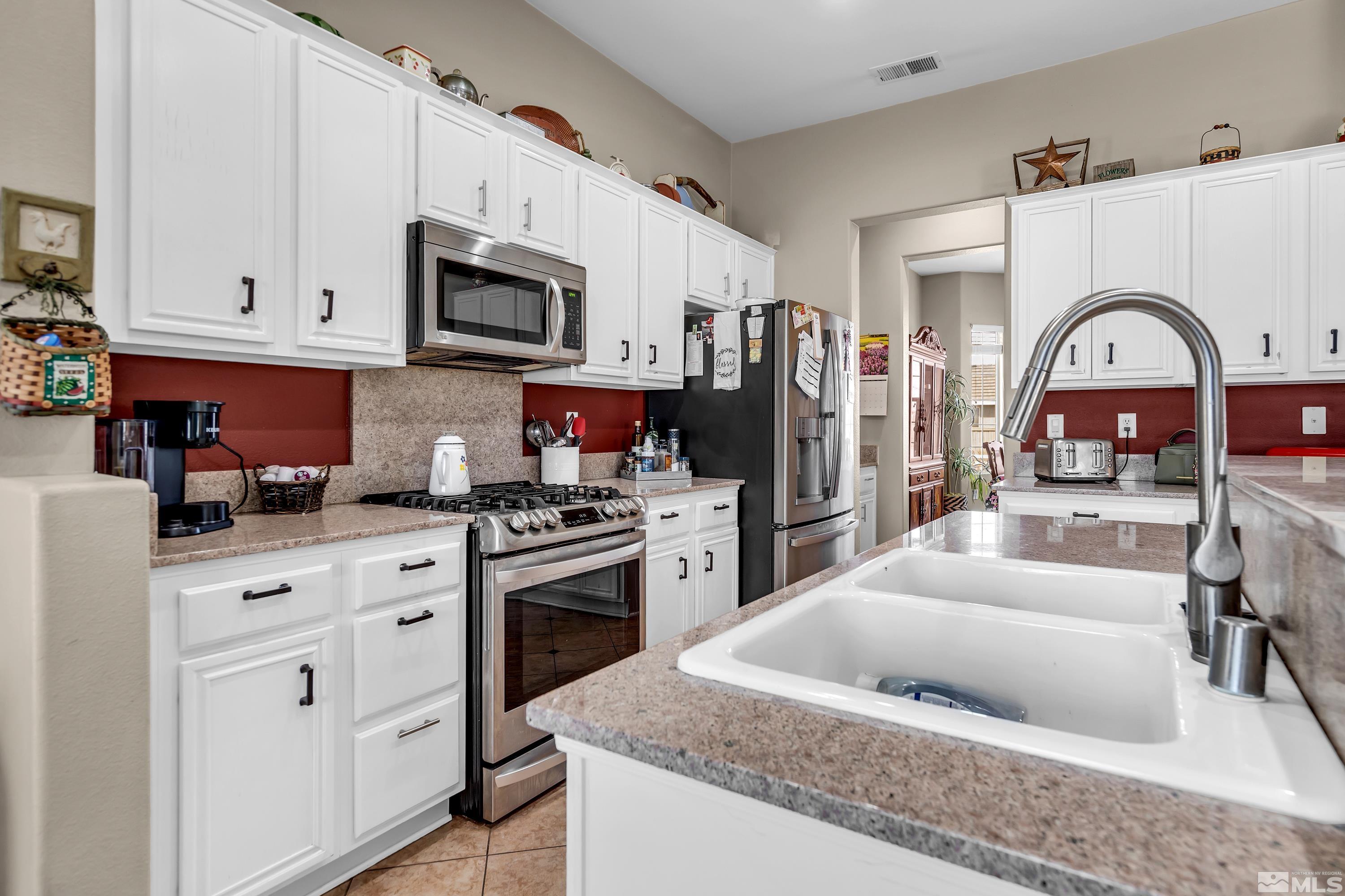 1496 Gaucho Lane Reno, NV 89521 - Photo 17 of 40 a kitchen with stainless steel appliances granite countertop a stove top oven a sink dishwasher and cabinets with wooden floor