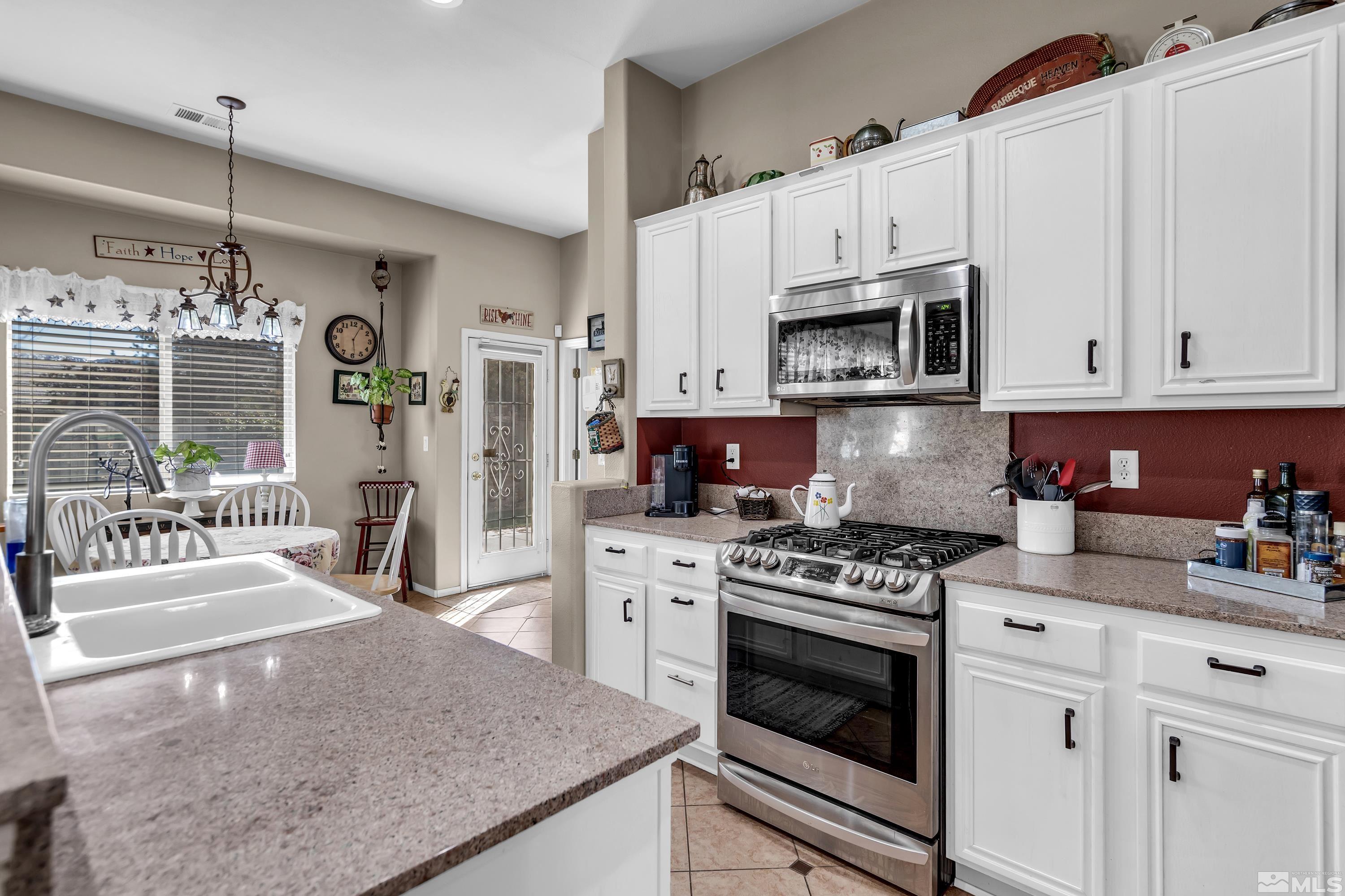 1496 Gaucho Lane Reno, NV 89521 - Photo 18 of 40 a kitchen with white cabinets and appliances