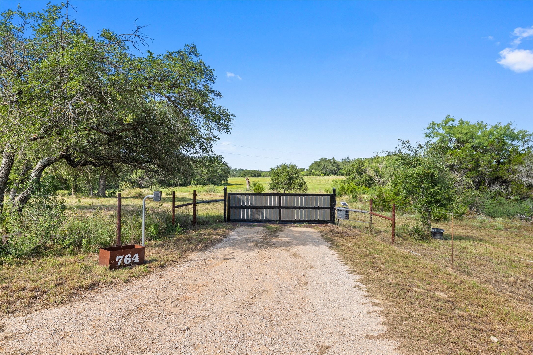 764 Stubbs Road Johnson City, TX 78636 - Photo 23 of 29 A private gate opens to a vast, natural landscape with mature trees and endless possibilities.
