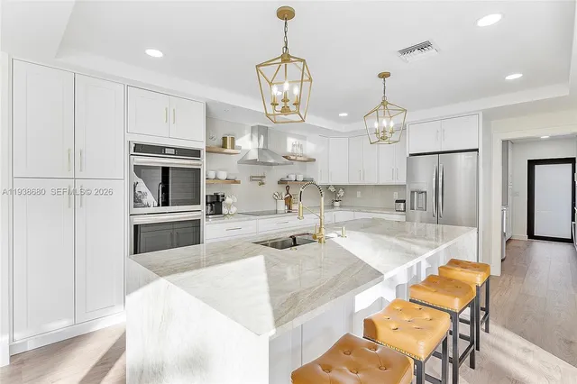a large white kitchen with refrigerator stove and oven