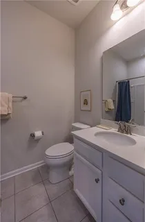 a bathroom with a granite countertop toilet sink and mirror