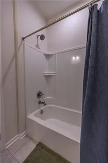 a white bath tub with shower