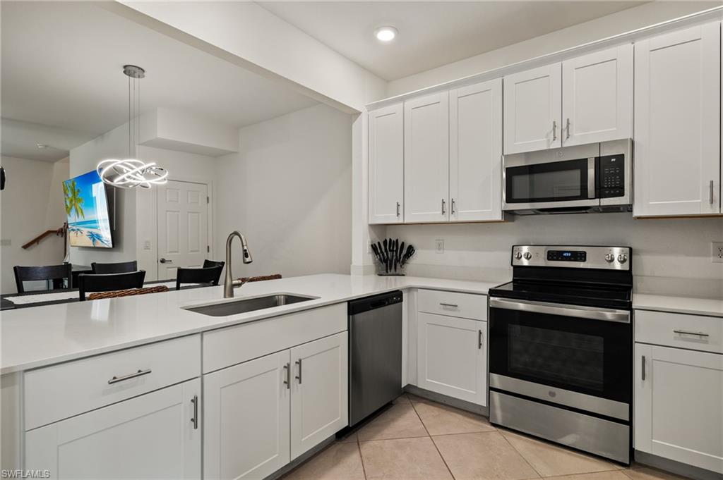 2934 Citrus Street Naples, FL 34120 - Photo 4 of 29 a kitchen with granite countertop white cabinets and stainless steel appliances