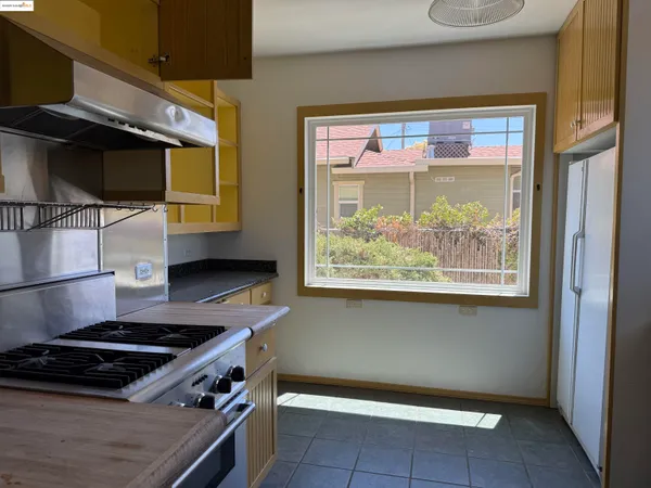 a kitchen with a stove and a wooden floor