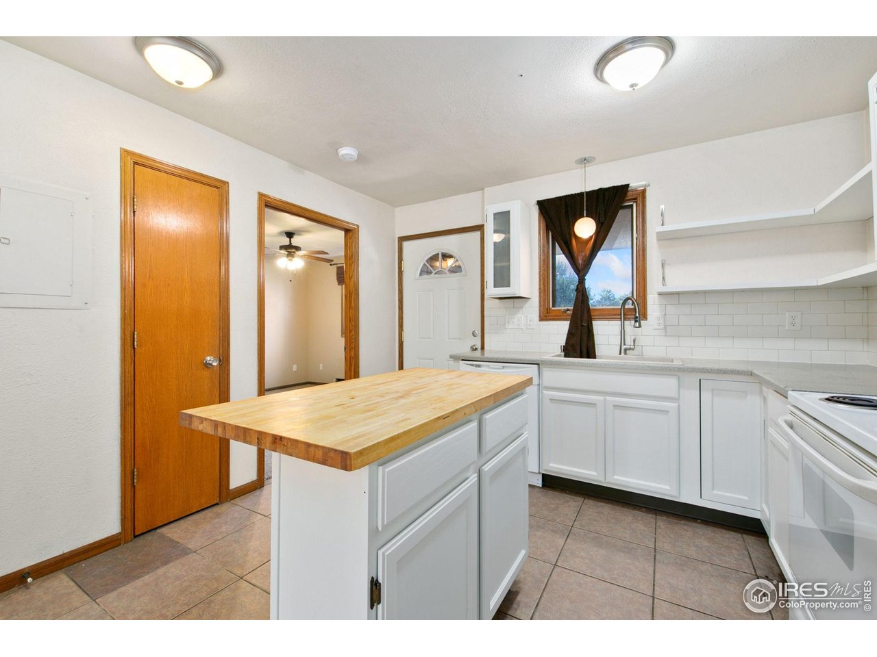 1231 West Swallow Road, Unit 316 Fort Collins, CO 80526 - Photo 18 of 42 a hall with kitchen island white cabinets and stainless steel appliances