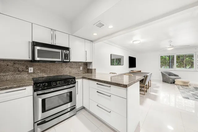a kitchen with stainless steel appliances granite countertop a stove microwave and sink