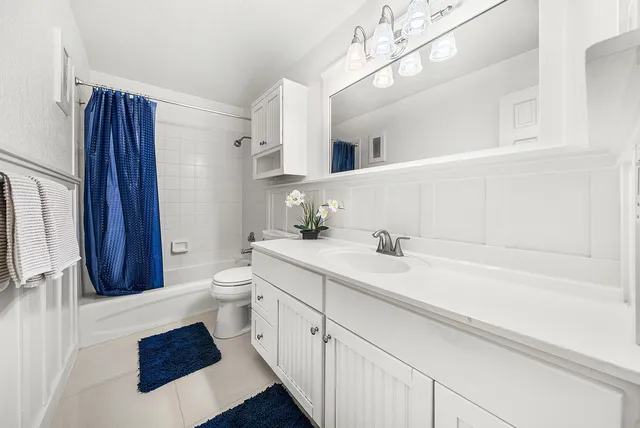 a spacious bathroom with a sink a toilet a mirror and shower