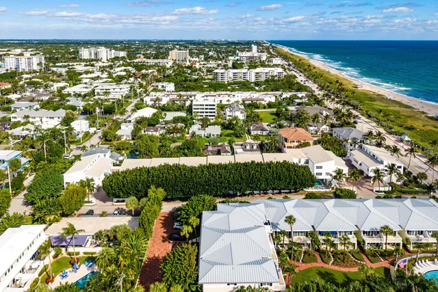 an aerial view of residential houses with outdoor space and trees