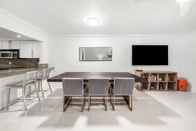 a view of a dining room with furniture and a flat screen tv