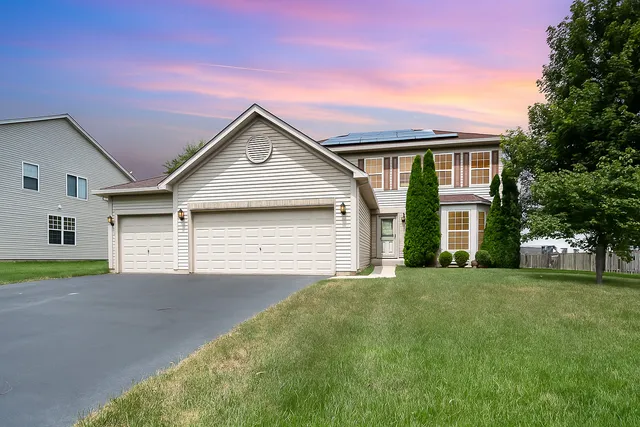 a front view of a house with a yard and garage