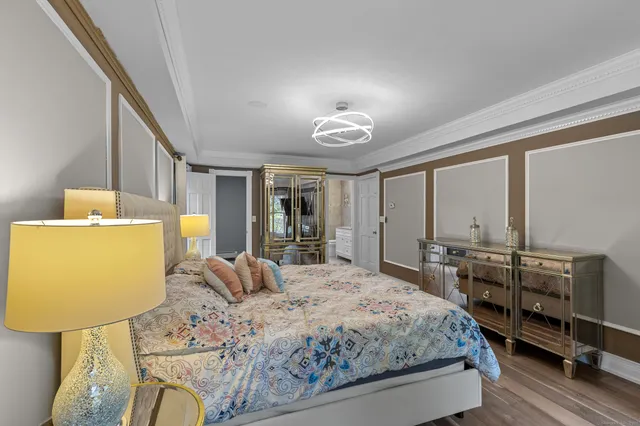 a bedroom with a bed and dresser with mirror