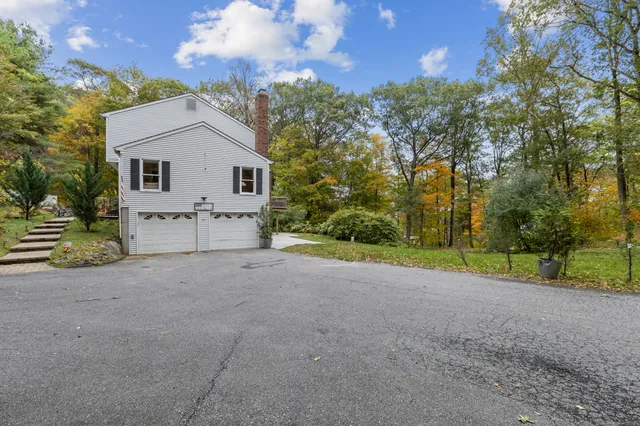 a view of a house with a yard and large tree