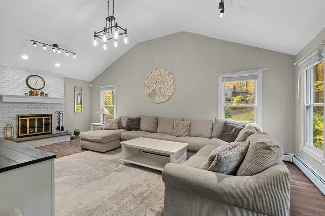 a living room with furniture a fireplace and a window