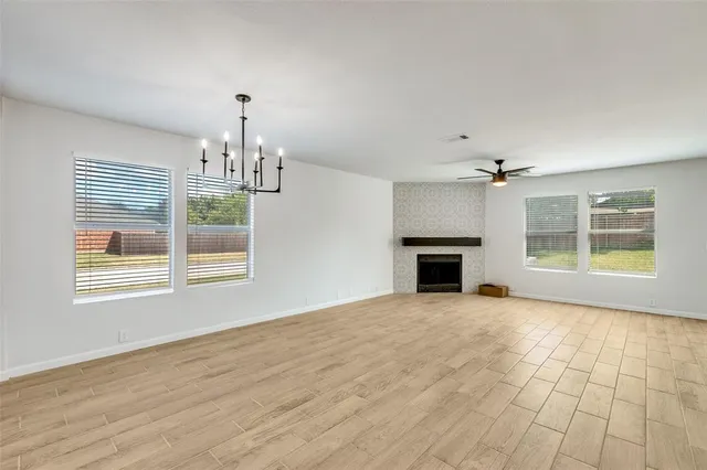 a view of an empty room with a window and fireplace