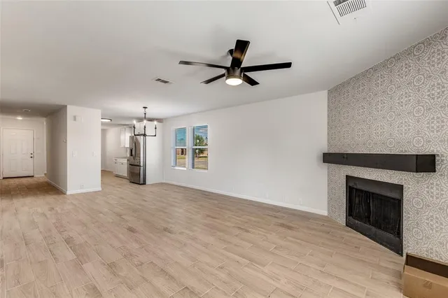 a view of empty room with wooden floor and fireplace