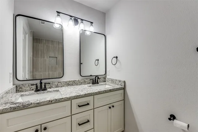 a bathroom with a granite countertop sink double and mirror
