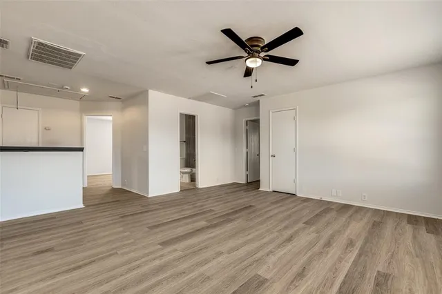 a view of a big room with wooden floor and a ceiling fan