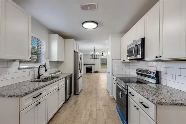 a kitchen with stainless steel appliances granite countertop a sink stove and refrigerator