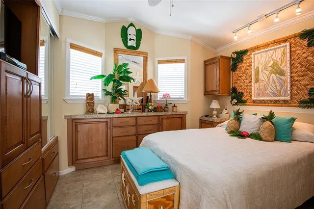a bedroom with a bed a window and potted plant on the dresser