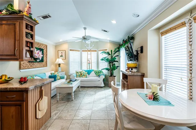 a living room with furniture a chandelier and a dining table