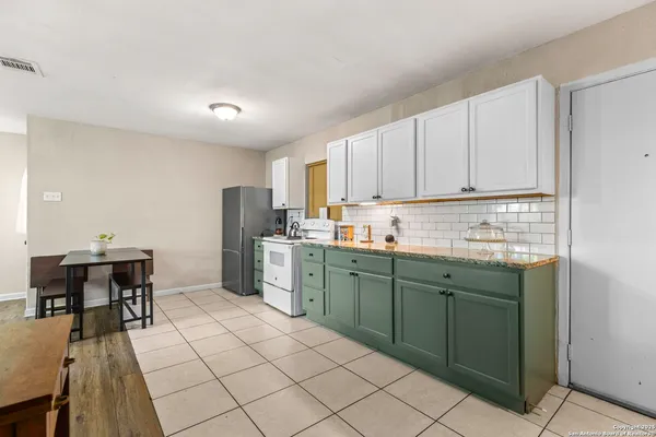 a kitchen with cabinets and chairs