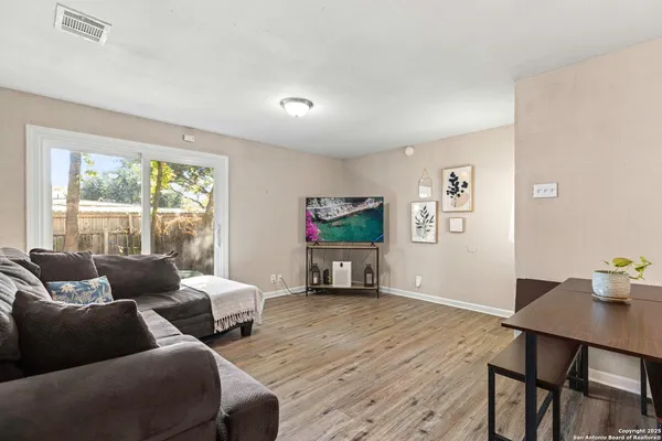 a living room with furniture two window and a flat screen tv