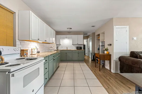 a kitchen with stainless steel appliances granite countertop a sink counter space cabinets and a large window