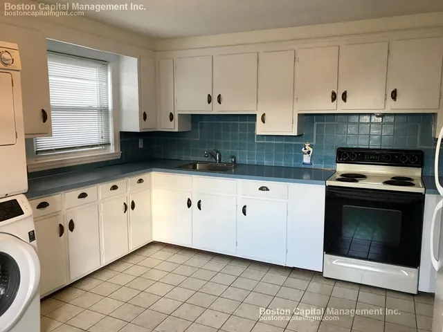 a kitchen with a refrigerator sink and cabinets