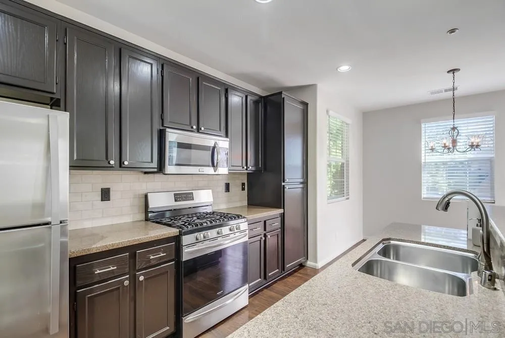 1298 Fools Gold Way, Unit 4 Chula Vista, CA 91913 - Photo 14 of 38 a kitchen with stainless steel appliances granite countertop a sink stove and refrigerator