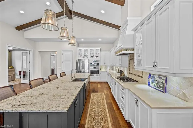 a kitchen with granite countertop a sink a counter space appliances and cabinets