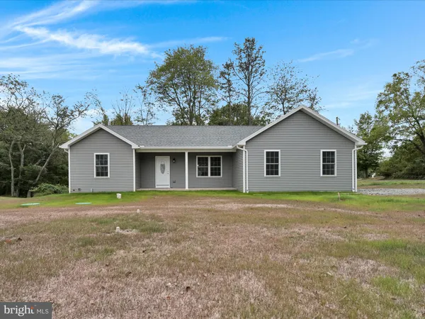 a front view of a house with a yard and trees